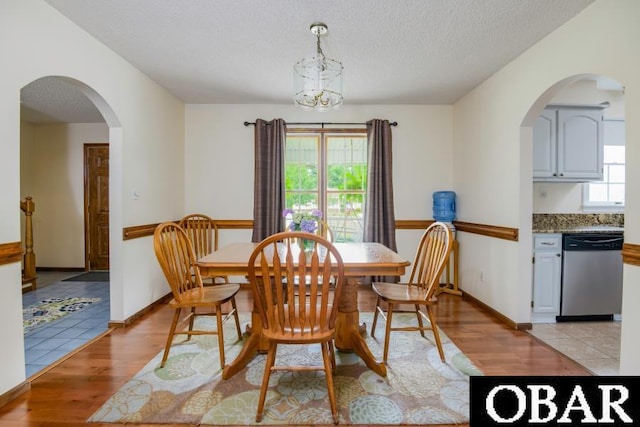 128 Daphne Ln Lot 17, Manteo, NC 27954 - dining room featuring light wood-style flooring, arched walkways, a textured ceiling, and a chandelier