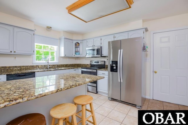128 Daphne Ln Lot 17, Manteo, NC 27954 - kitchen with stainless steel appliances, light stone countertops, a kitchen bar, and light tile patterned floors