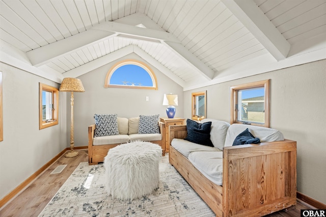 living area with light wood-type flooring, visible vents, vaulted ceiling with beams, and baseboards