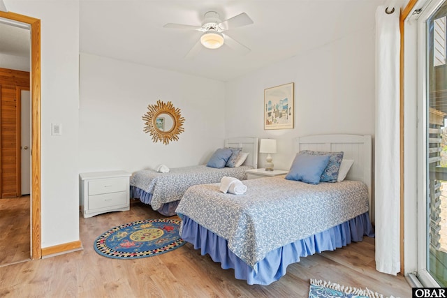 bedroom with ceiling fan, baseboards, and wood finished floors