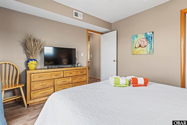 bedroom with visible vents and wood finished floors