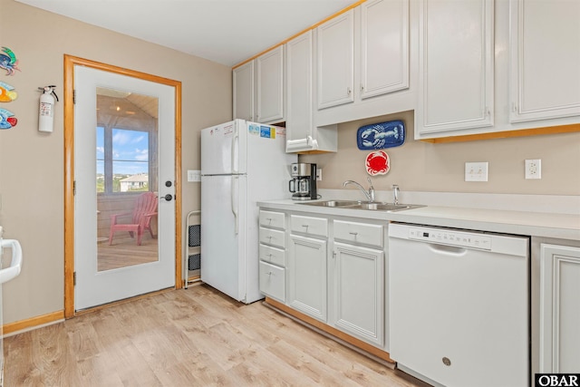 kitchen featuring light countertops, white appliances, a sink, and white cabinets