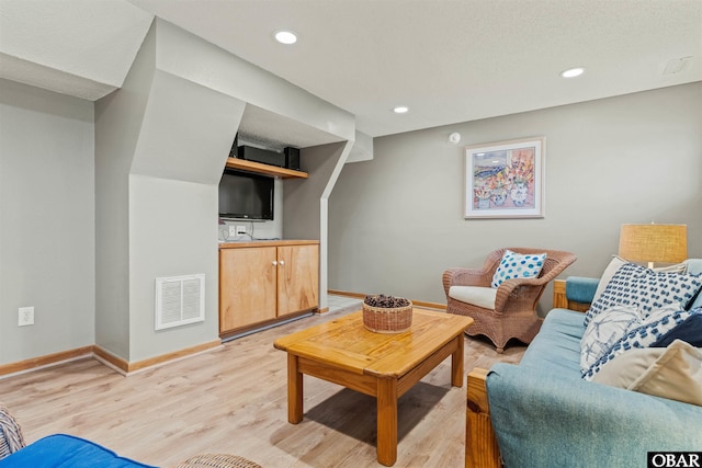 living area with baseboards, recessed lighting, visible vents, and light wood-style floors