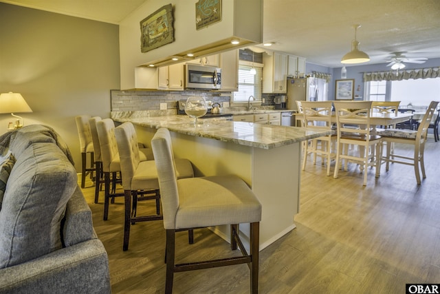 400 Driftwood Dr Lot 168, Elizabeth City, NC 27909 - kitchen with stainless steel appliances, a peninsula, ceiling fan, backsplash, and a sink