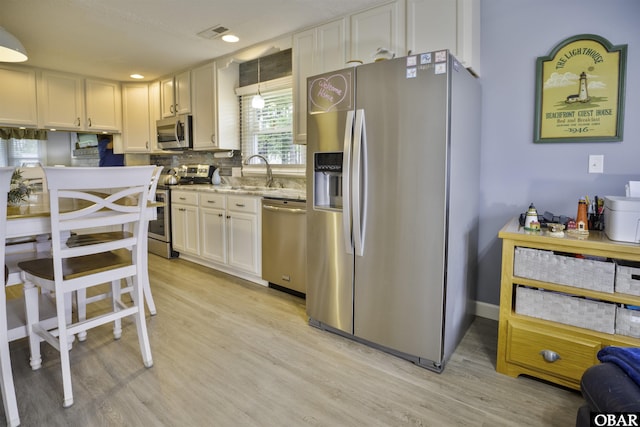 400 Driftwood Dr Lot 168, Elizabeth City, NC 27909 - kitchen featuring stainless steel appliances, light wood-style flooring, a sink, white cabinetry, and backsplash