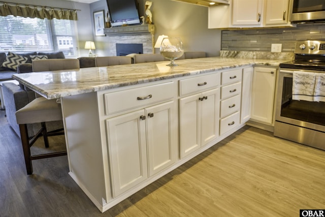 400 Driftwood Dr Lot 168, Elizabeth City, NC 27909 - kitchen with stainless steel appliances, open floor plan, light wood-type flooring, white cabinets, and a kitchen breakfast bar