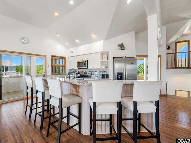 2250 Ocean Pearl Rd Lot 13, Corolla, NC 27927 - kitchen featuring appliances with stainless steel finishes, open shelves, white cabinets, dark wood-style floors, and a breakfast bar area
