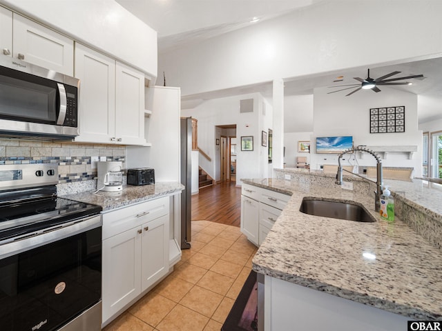 2250 Ocean Pearl Rd Lot 13, Corolla, NC 27927 - kitchen featuring stainless steel appliances, a sink, open floor plan, white cabinetry, and ceiling fan
