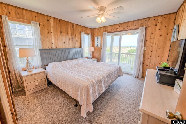 42075 Ocean View Dr Lot 3, Avon, NC 27943 - bedroom with access to exterior, light colored carpet, wooden walls, and ceiling fan