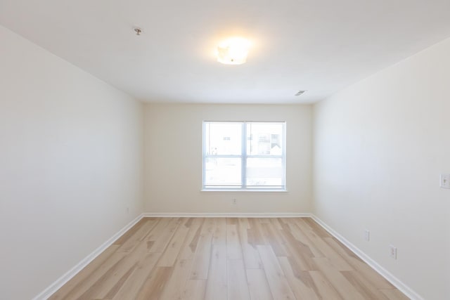 unfurnished room featuring light wood finished floors and baseboards