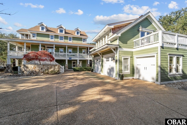 view of front of property with a garage, a balcony, and driveway