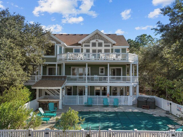 back of property featuring a balcony, a fenced backyard, a fenced in pool, and a patio