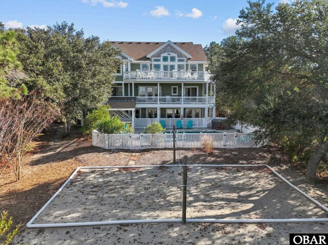 rear view of property with fence private yard, a balcony, and a fenced in pool