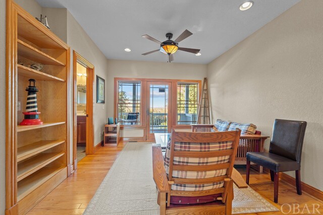 living area featuring light wood-style flooring, baseboards, a ceiling fan, and recessed lighting