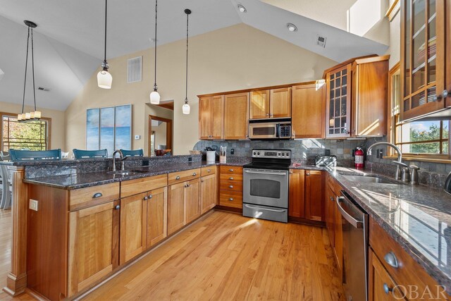 kitchen with visible vents, appliances with stainless steel finishes, brown cabinets, and pendant lighting