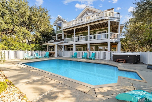 rear view of house featuring a patio area, a hot tub, fence, and a fenced in pool