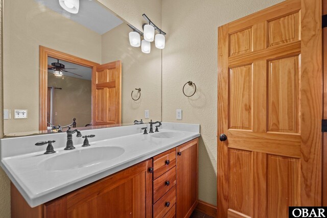 bathroom featuring double vanity, a sink, and a textured wall