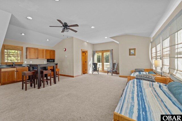 bedroom with lofted ceiling, recessed lighting, light colored carpet, a sink, and baseboards