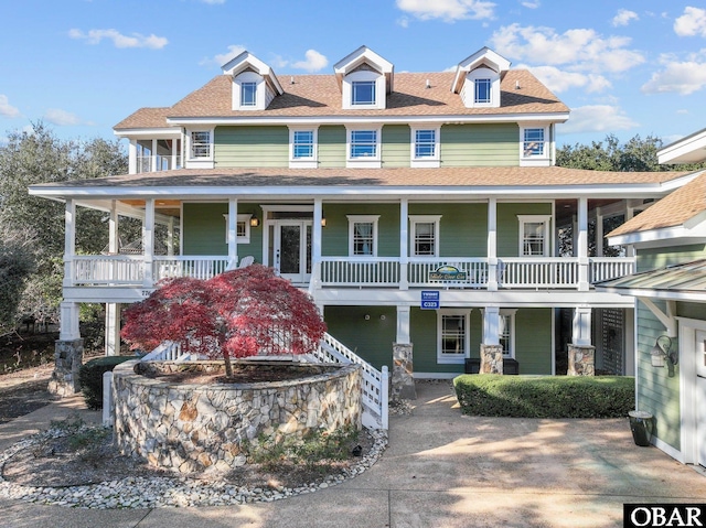 view of front facade with covered porch and roof with shingles