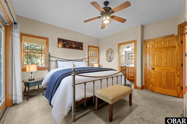 bedroom featuring light carpet, ceiling fan, and ensuite bathroom