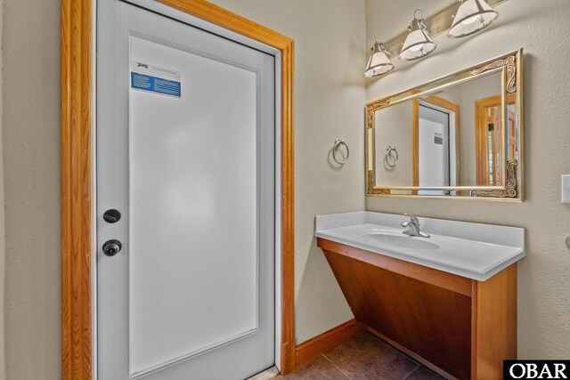 bathroom with baseboards, vanity, and tile patterned floors