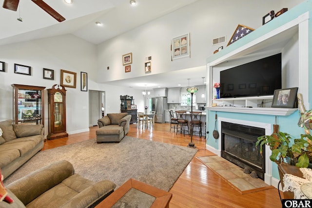 102 Lighthouse Vw Lot 5, Aydlett, NC 27916 - living area with high vaulted ceiling, light wood finished floors, ceiling fan, and a fireplace with flush hearth