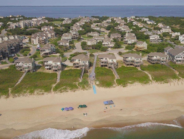 drone / aerial view with a water view, a residential view, and a beach view