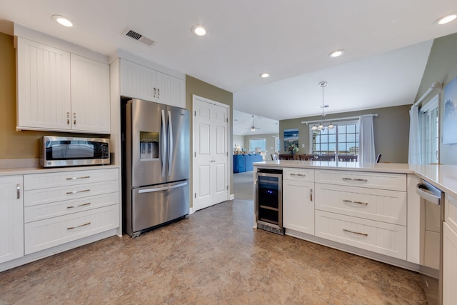 kitchen featuring beverage cooler, visible vents, stainless steel appliances, light countertops, and pendant lighting