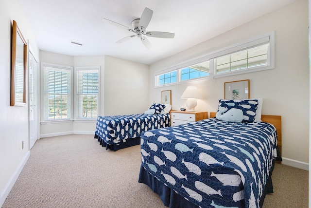 bedroom with light carpet, visible vents, baseboards, and ceiling fan