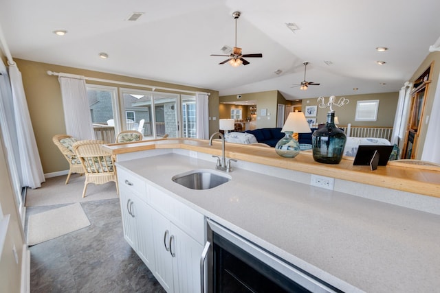 kitchen with lofted ceiling, light countertops, visible vents, open floor plan, and a sink