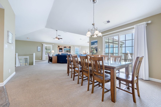 dining space with baseboards, ceiling fan with notable chandelier, visible vents, and light colored carpet