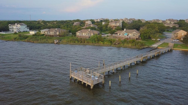 view of dock with a pier, a residential view, and a water view