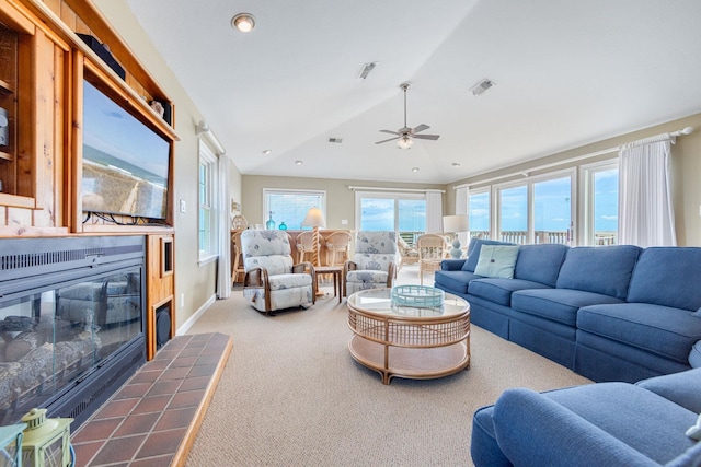 carpeted living room with lofted ceiling, baseboards, a fireplace, and visible vents