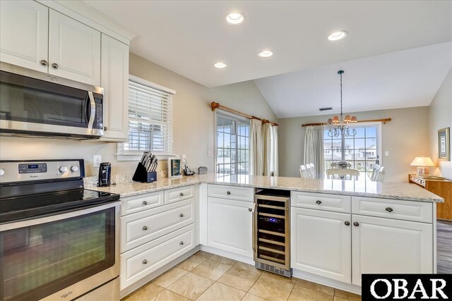 kitchen with appliances with stainless steel finishes, wine cooler, and white cabinets