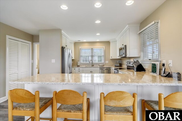 kitchen featuring a peninsula, appliances with stainless steel finishes, and a breakfast bar area