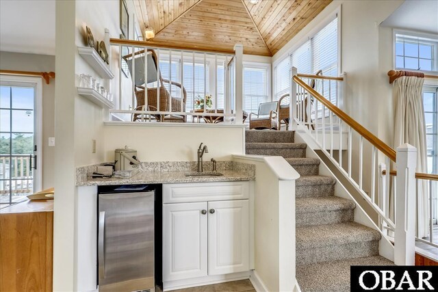 bar with a sink, wood ceiling, stairs, vaulted ceiling, and freestanding refrigerator