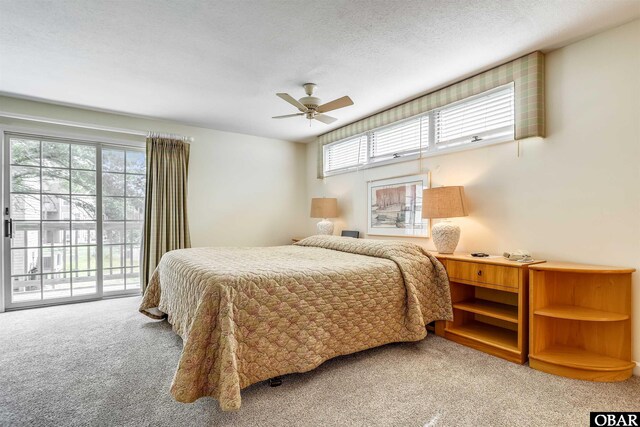 carpeted bedroom with access to exterior, a ceiling fan, and a textured ceiling