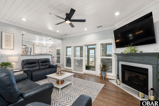 living area with crown molding, a fireplace, visible vents, dark wood-type flooring, and wood ceiling