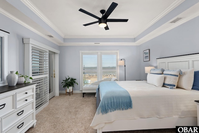 bedroom with ornamental molding, a tray ceiling, visible vents, and light carpet