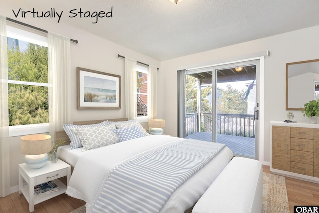 549 White Whale Way Lot # 220E, Corolla, NC 27927 - bedroom featuring access to exterior, light wood-style floors, baseboards, and a textured ceiling