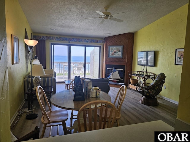 2035 S Virginia Dare Trl Unit 11, Kill Devil Hills, NC 27948 - dining room with a textured wall, wood finished floors, a textured ceiling, a ceiling fan, and baseboards