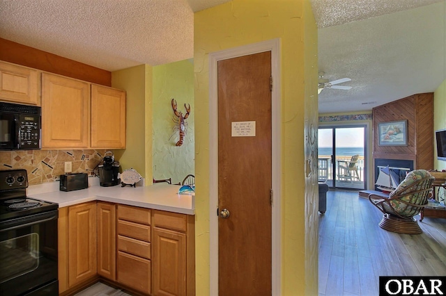 2035 S Virginia Dare Trl Unit 11, Kill Devil Hills, NC 27948 - kitchen with black appliances, a textured ceiling, backsplash, wood finished floors, and ceiling fan