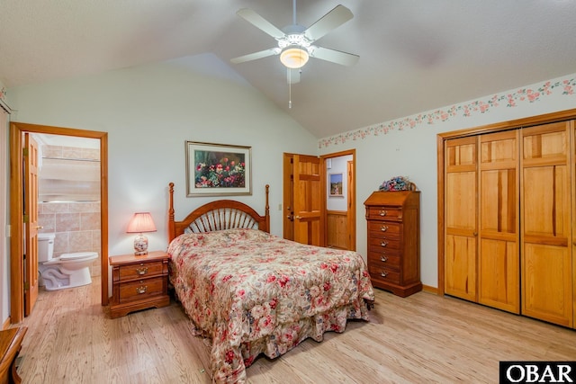 bedroom featuring light wood finished floors, lofted ceiling, ceiling fan, a closet, and connected bathroom