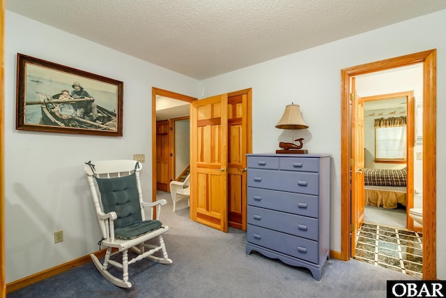 sitting room with stairway, carpet flooring, baseboards, and a textured ceiling