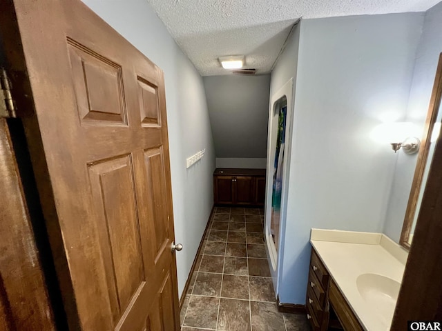 108 Loop Rd, Ocracoke, NC 27960 - bathroom with a textured ceiling, vanity, a shower, and baseboards