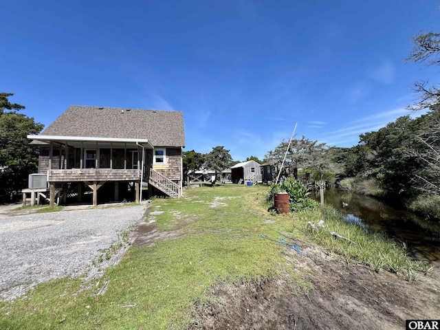 108 Loop Rd, Ocracoke, NC 27960 - view of green lawn with a sunroom and stairway