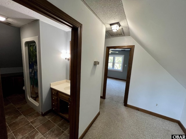 108 Loop Rd, Ocracoke, NC 27960 - bathroom with a textured ceiling, vanity, lofted ceiling, and baseboards