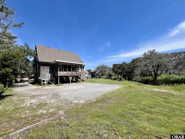 108 Loop Rd, Ocracoke, NC 27960 - back of house with stairs, a sunroom, and a yard