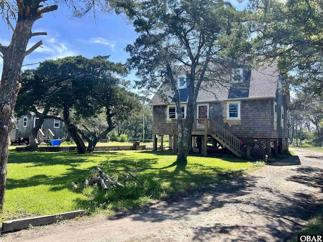 108 Loop Rd, Ocracoke, NC 27960 - view of front facade featuring a front yard, stairway, and a shingled roof