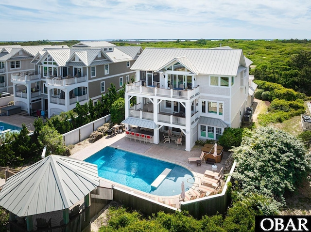 367 Lindsey Ln Lot 1, Corolla, NC 27927 - back of house featuring metal roof, a patio area, a fenced in pool, a balcony, and a fenced backyard
